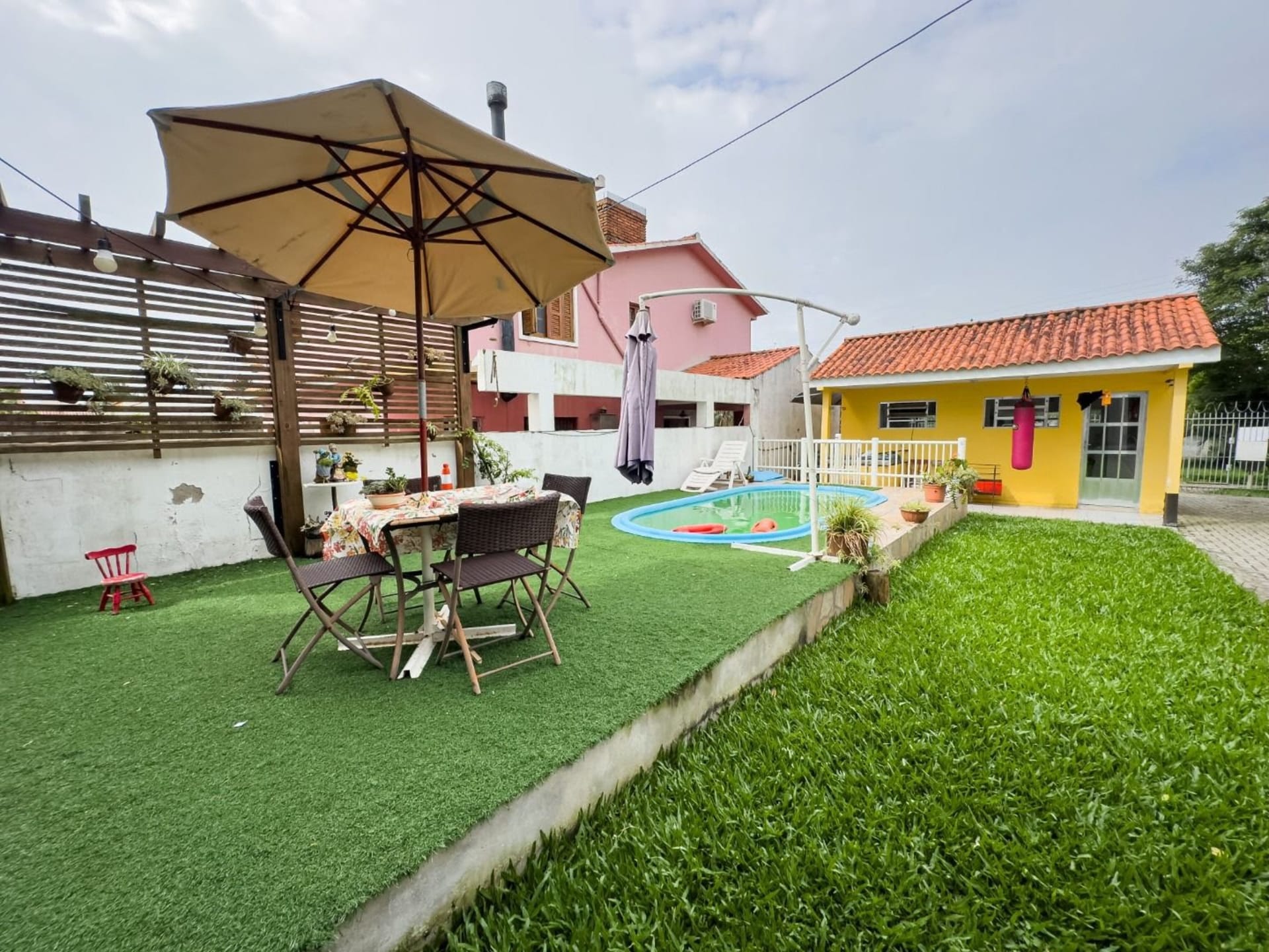 Casa à venda no Laranjal, Pelotas - 208 m², 3 quartos (sendo 1 suíte), lareira e área de lazer com piscina e amplo pátio.