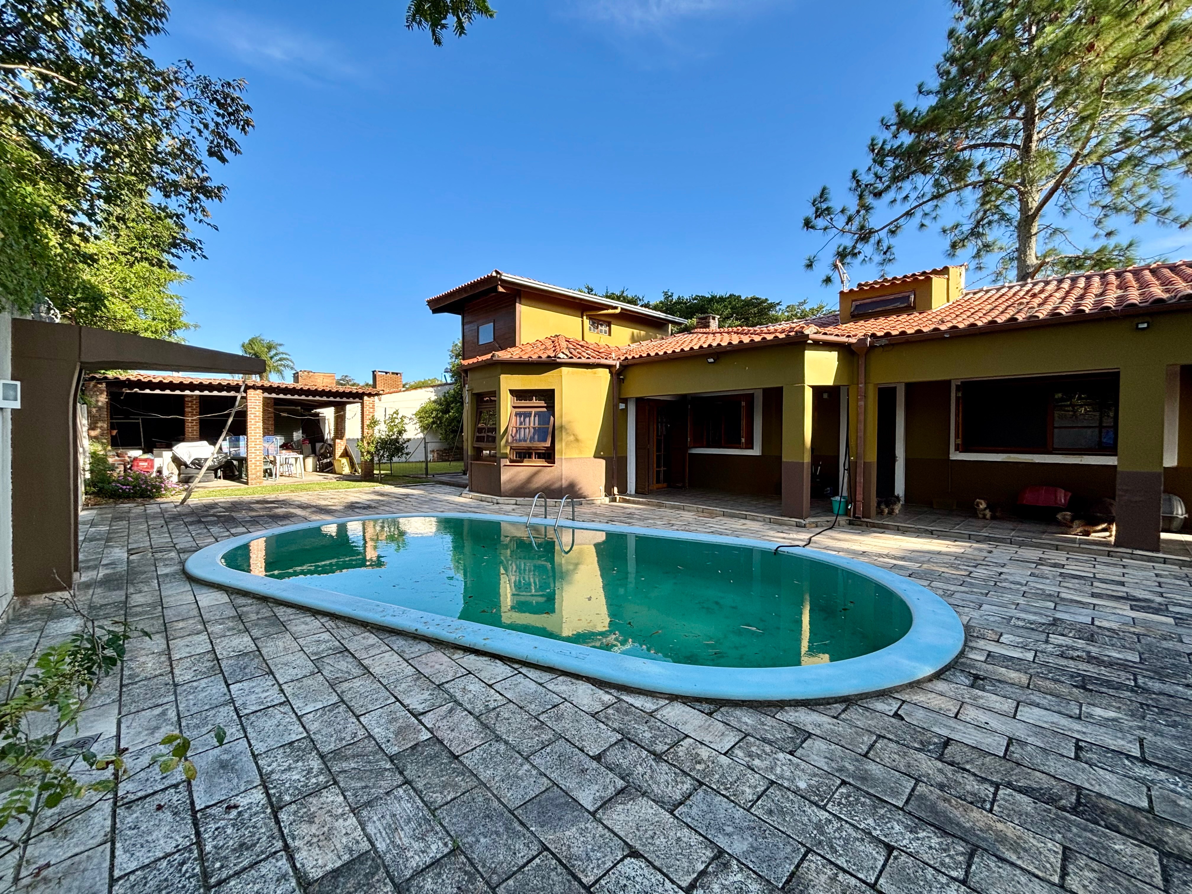 Casa à venda no Laranjal, Pelotas - 210 m², 2 quartos, cozinha planejada e amplo pátio com área gourmet, piscina e árvores frutíferas. - 18